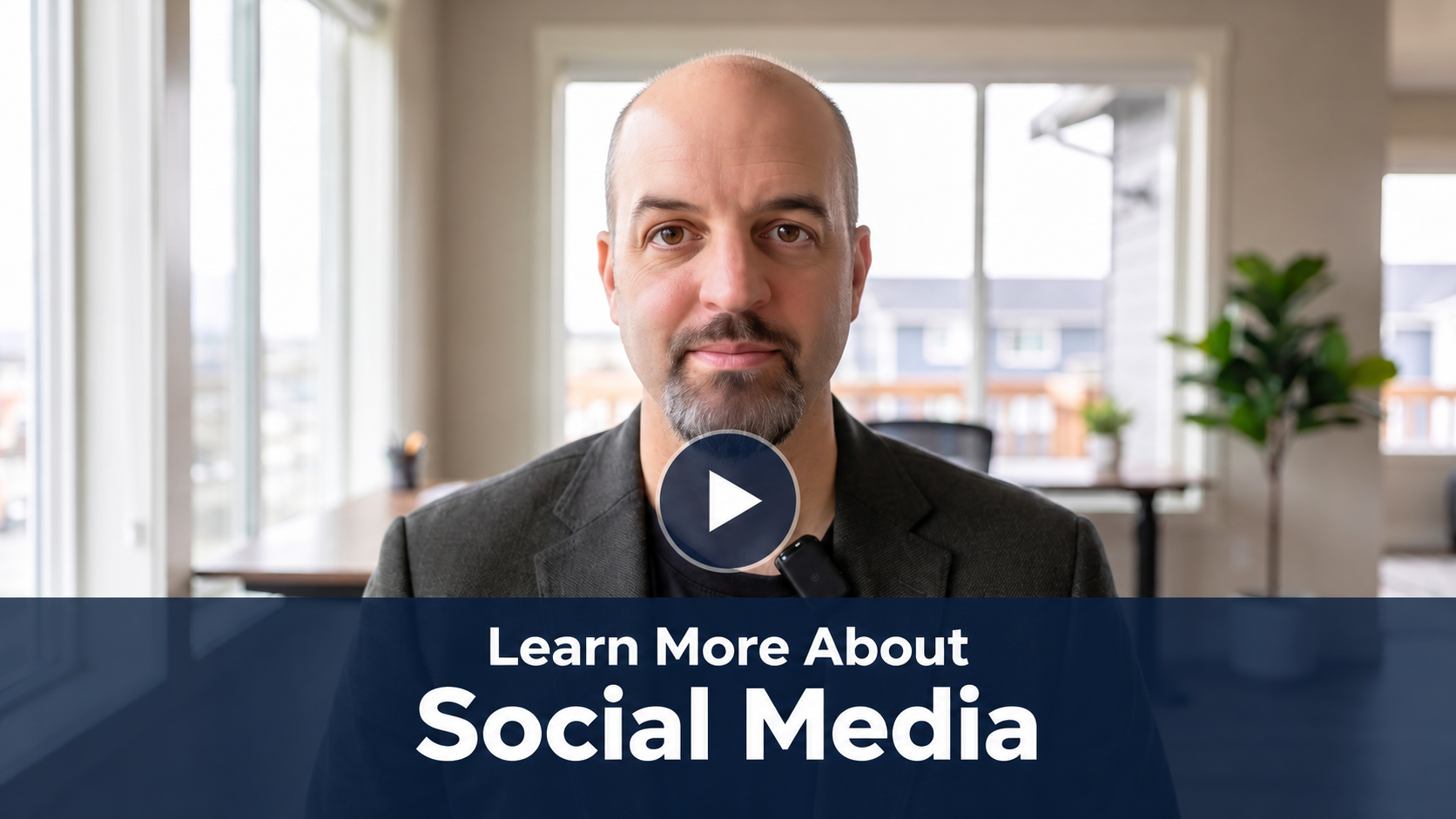 Video thumbnail: man in a blazer in an office with a blue overlay banner reading 'Learn More About Social Media' and a play button in the center.